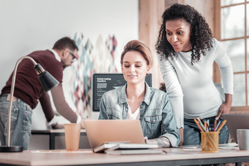 Cheerful blonde girl typing message to her colleague