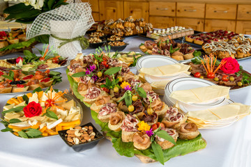 Close up of small canapes arranged on a plate over light background - selective focus