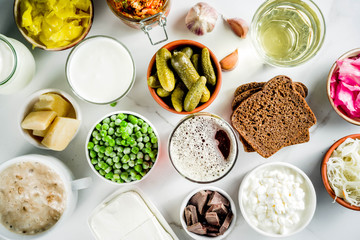Super Healthy Probiotic Fermented Food Sources, drinks, ingredients, on white marble background copy space top view