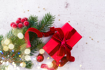 Christmas gift giving flat lay scene - christmas present wrapped in red on white wooden table with bokeh lights
