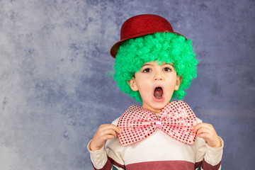 Little boy with a green wig, red hat and a bow tie