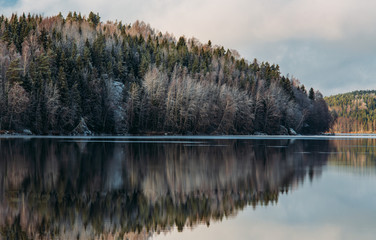 Incredible reflections in the lake with beautiful sunset light. The first frosts in Scandinavia, Finland
