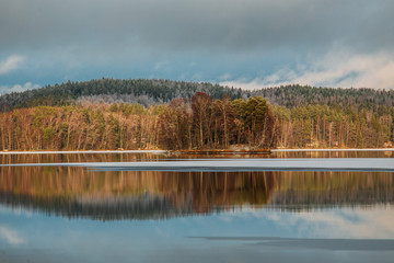 Incredible reflections in the lake with beautiful sunset light. The first frosts in Scandinavia, Finland
