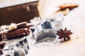 Star anise cookie cutter cinnamon and flour on baking board. Christmas baking utensil and holiday...