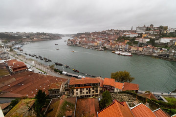 Porto city in rainy and windy weather, Portugal. Cityscape with famous Luis I Bridge from the Vila Nova de Gaia side.