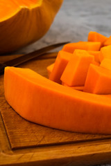 Preparation of ripe pumpkin. Cut the orange pulp into pieces. Kitchen cutting Board. Vegetarian food. Raw vegetables.