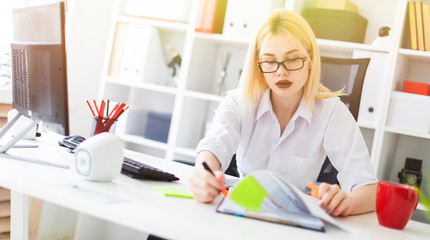 A young girl working in the office with a computer and documents.