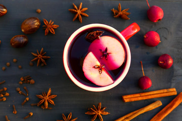 Christmas mulled wine with spices and apple in red mug