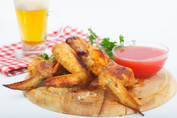 Bbq chicken wings with red sauce and beer. Grilled chicken wings with glass of beer..