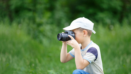 Fototapeta premium Small funny boy practicing in taking photography