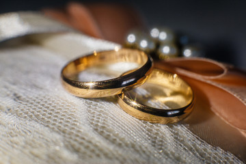 Two gold wedding rings close up on dark background