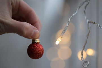 Red Christmas balls with decoration on shiny background, outside holding in hand