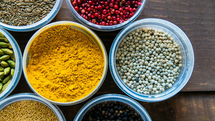 Various colorful spices in plastic containers top view