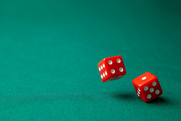 Two red dice on green poker gaming table in casino. Concept online gambling. Copy space for text