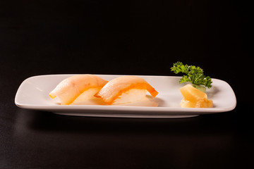 Nigiri Shiromi sushi with salmon fish on black background