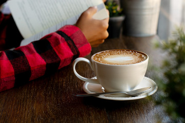 Woman is reading a book in a coffee shop