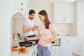 Young couple preparing food in the kitchen.