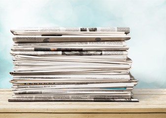 Pile of newspapers on white background, close up