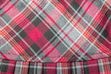 Detail of new fashion plaid pleated skirt: red, maroon, gray tartan school uniform fabric cotton/woolen material, blurred focus