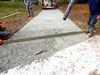 Worker pouring cement onto driveway from the cement lorry