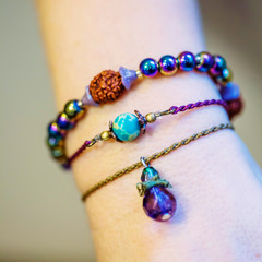 Three bracelets with natural stone beads on female hand