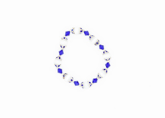 blue and white colored and variously sized beads bracelet on white background