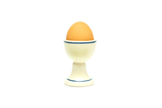 boiled chicken egg in a ceramic stand on a white background