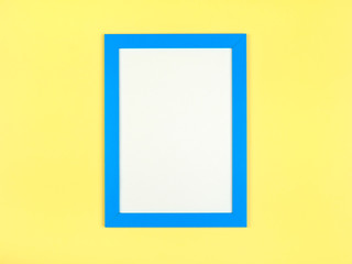 Flat lay pastel colored background with empty picture frame