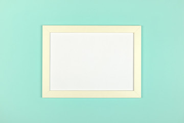 Empty picture frame on textured pastel colored background