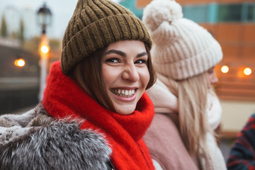 Happy young friends talking with each other outdoors winter concept.