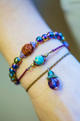 Three bracelets with natural stone beads on female hand