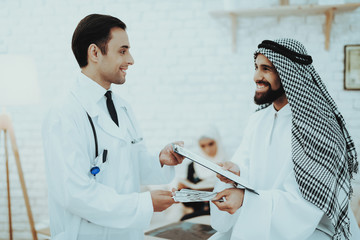 Arabic Patient Giving Dollars Money to Doctor.