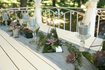 Florarium with fresh succulent and rose flowers festive table decoration. Event fresh flowers decoration. Florist workflow. Wedding ceremony  design