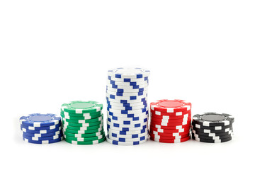 Casino games concept,Stacks of poker chipson gamble table including red, black, white, green and blue on a white background.