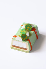 Contemporary Green Tea Mousse Cake with tropical fruits, on white background.