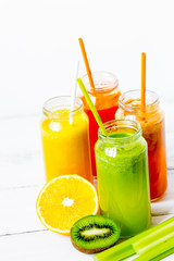 Fresh detox juices in glass bottles on white background