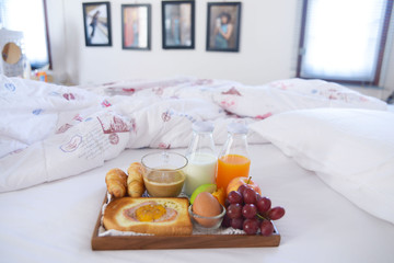 Fototapeta na wymiar Breakfast on bed with coffee, croissants Window light 