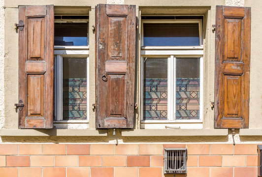 Fassade mit Fenstern mit Glasmalerei und Fensterläden aus Holz
