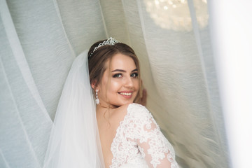 Portrait of a bride in a wedding dress. The bride dresses in the hotel