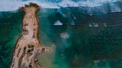 Top view of peninsula with boat. Aerial drone shot of turquoise water.