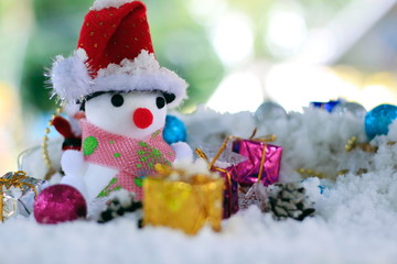 Snow man with a Christmas ornament on a snow background blur.