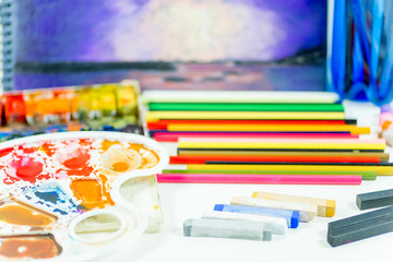 work space on a table with pencils and paintbrushes
