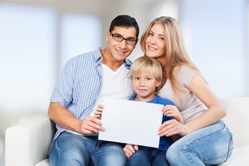 Beautiful smiling family sitting at sofa at home