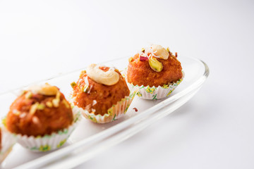 Carrot Halwa Laddu or sweet balls,  served in a plate with dry fruits toppings. selective focus