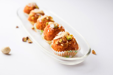 Carrot Halwa Laddu or sweet balls,  served in a plate with dry fruits toppings. selective focus