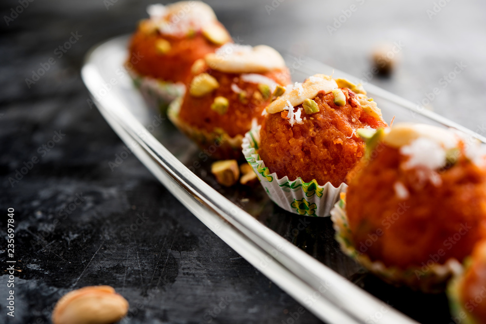 Wall mural Carrot Halwa Laddu or sweet balls,  served in a plate with dry fruits toppings. selective focus