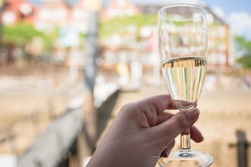 Glass of champagne at the woman hand. Beautiful city view background. Bremen, Germany.