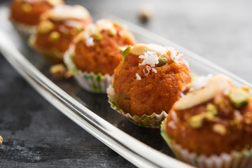 Carrot Halwa Laddu or sweet balls,  served in a plate with dry fruits toppings. selective focus