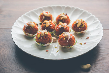 Carrot Halwa Laddu or sweet balls,  served in a plate with dry fruits toppings. selective focus