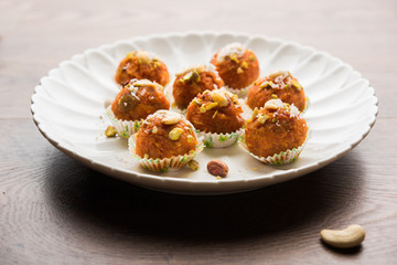 Carrot Halwa Laddu or sweet balls,  served in a plate with dry fruits toppings. selective focus